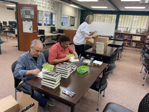 Neal Shusterman and Eric Elfman signing books in the PHS library.