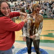 Hannah Rowley dumps food on her sister, Karen, during the Penny Wars assembly. 
